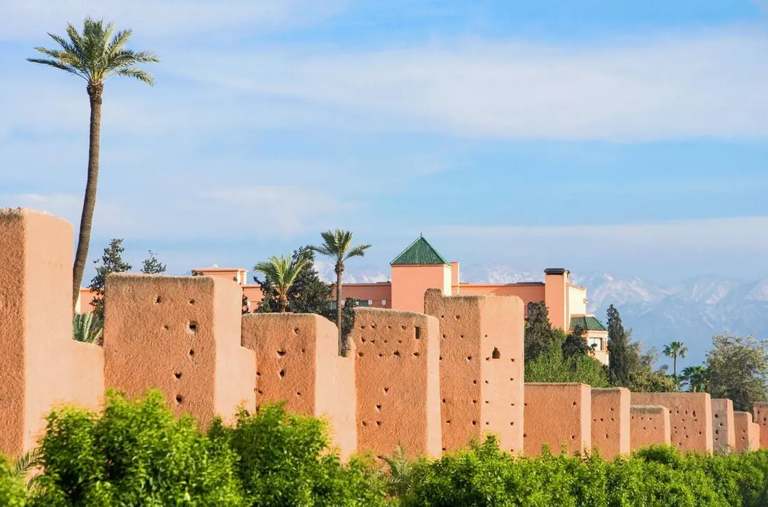 Ochre ramparts of Marrakech lined with palm trees