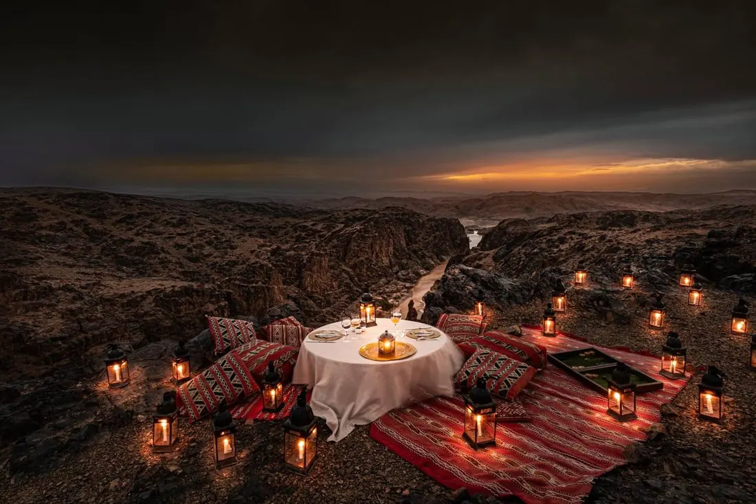 A candlelit dinner set among the rocks at dusk