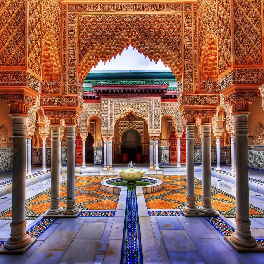 Ornate tiled courtyard with a central fountain in a Moroccan palace